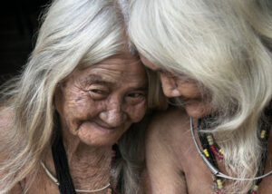 Ein altes Paar aus einer indigenen Kultur schmiegt sich zärtlich aneinander.